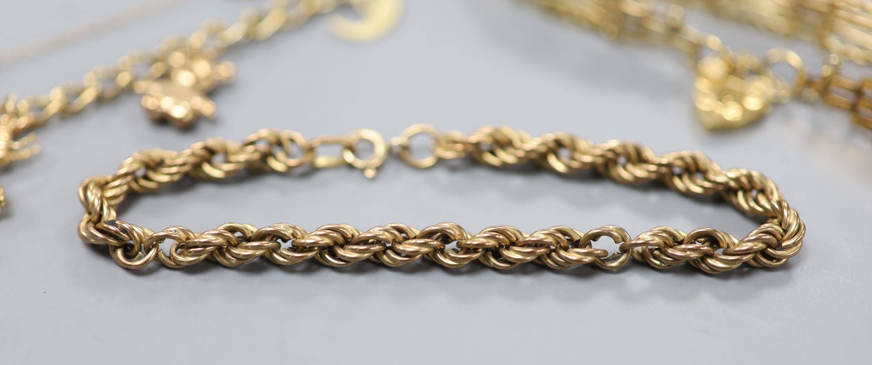 Three assorted modern 9ct gold bracelets, including charm and ropetwist